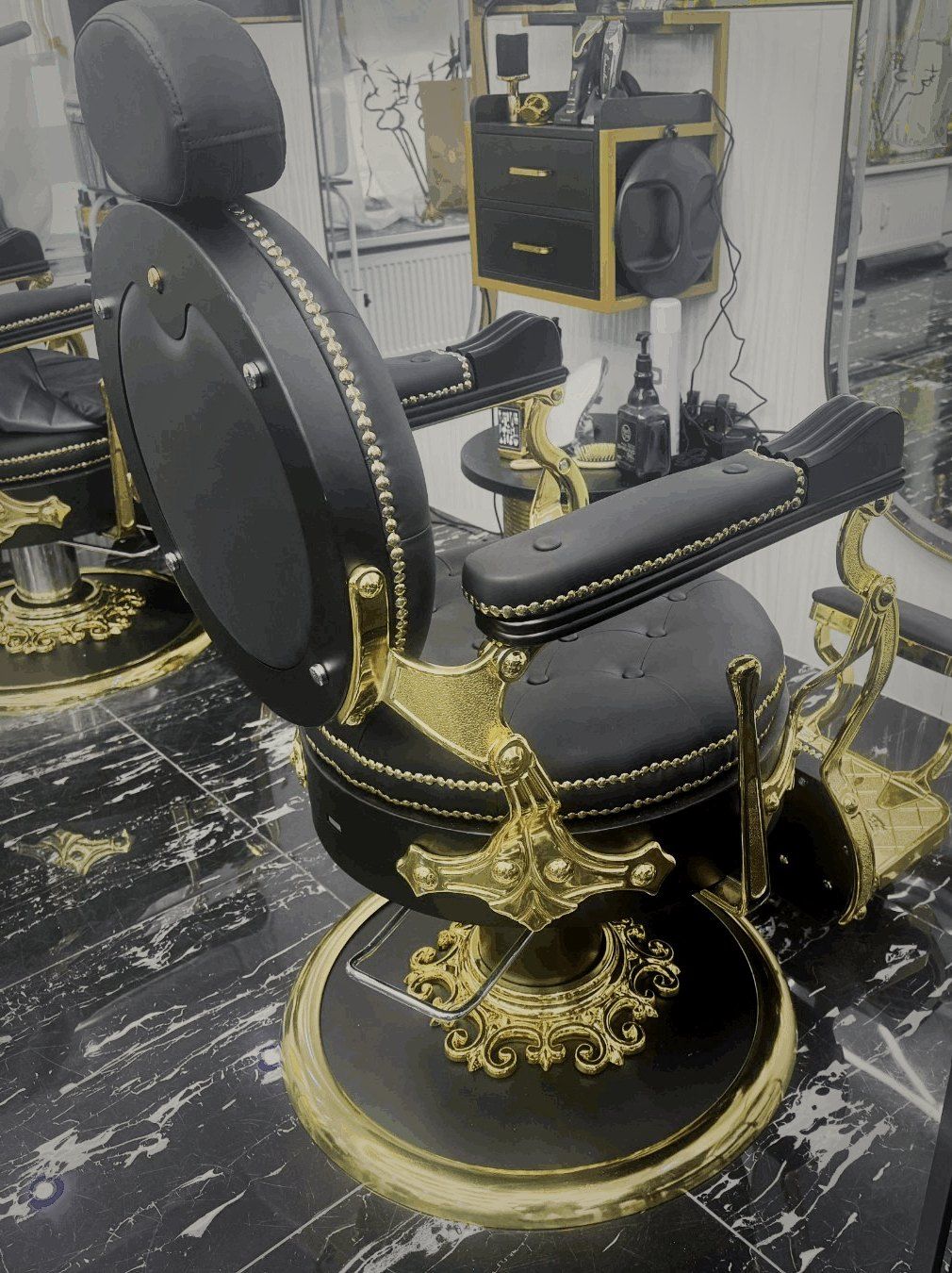 Vintage-Barberstuhl mit Gold-Details auf schwarzem Marmor im Friseur 5 Sterne